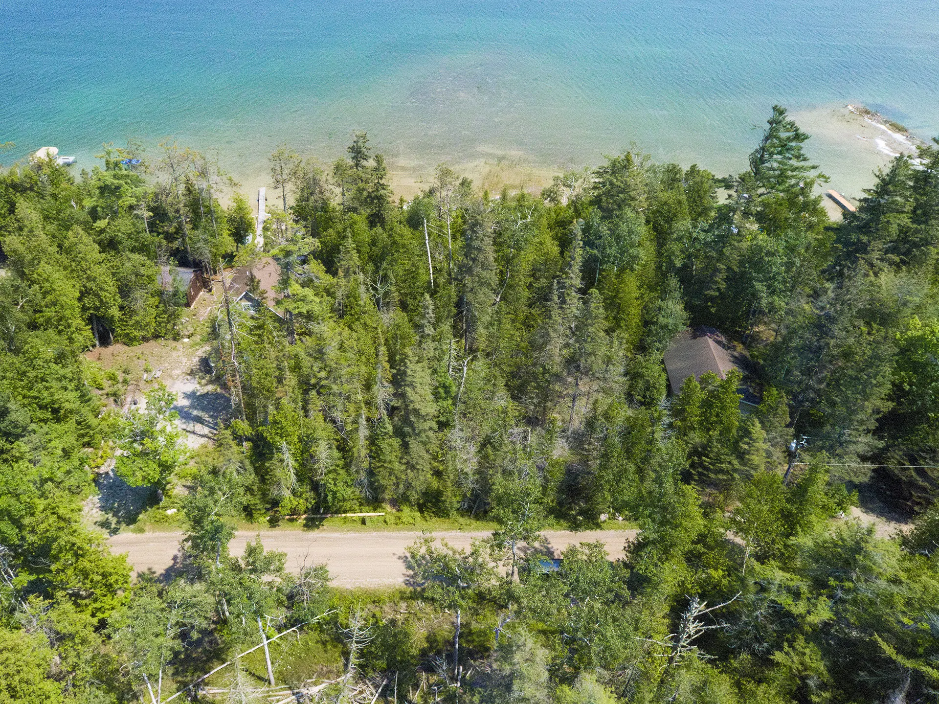 Aerial view of wooded shoreline and shallow dock